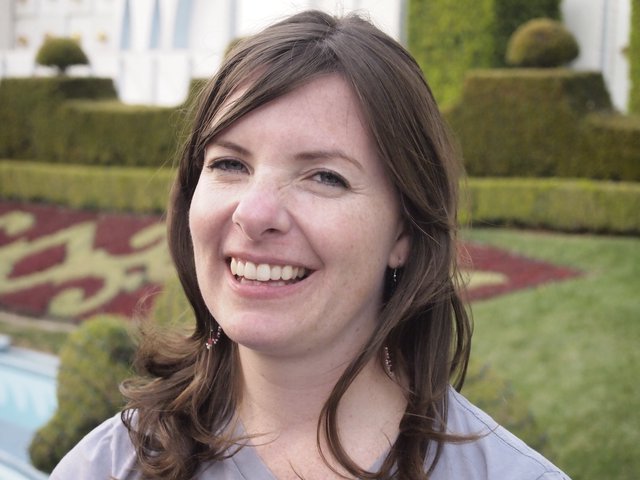 Joyful Woman Smiling at Formal Garden