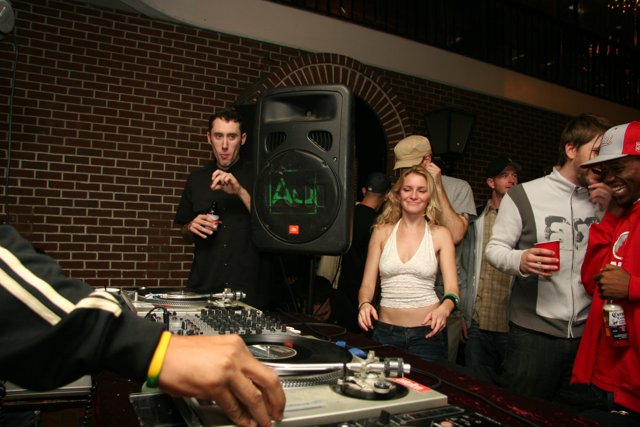 DJ in Black Jacket Spins Music at Nightclub