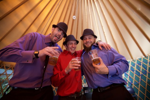 Three Men Cheers-ing Inside a Yurt at a Wedding