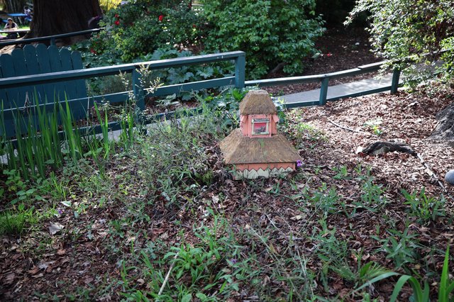 Whimsical Thatched Fairy House in Garden Setting
