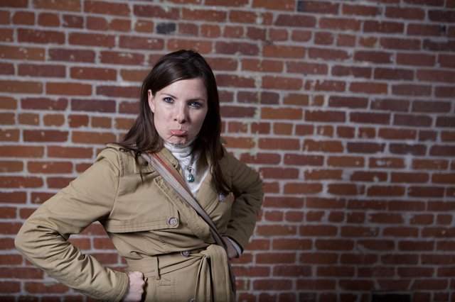 Defiant Woman Poses Against Urban Brick Wall