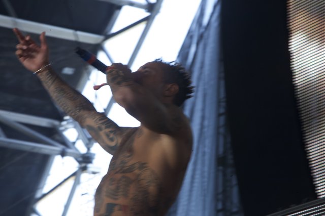 Tattooed Man on Stage with Microphone