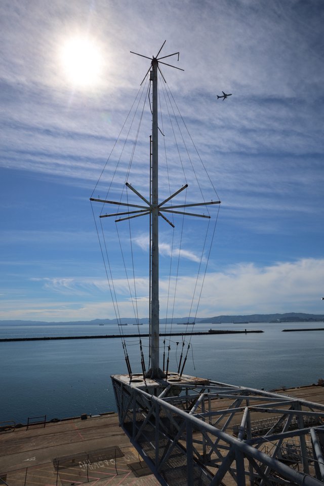Antenna Mast Silhouette Against Bay Waters and Sky