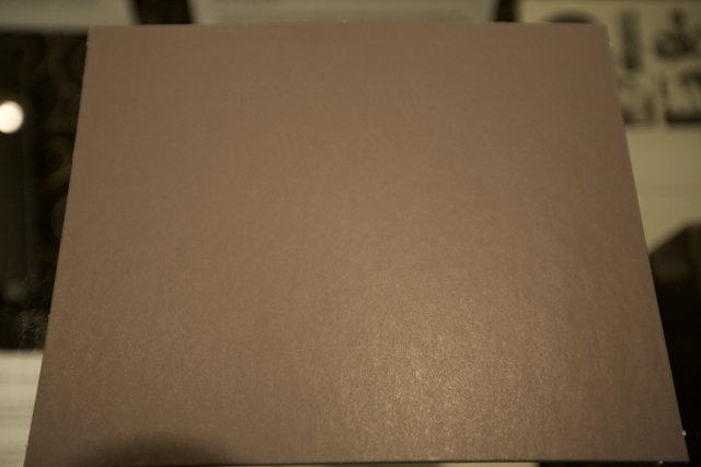 Texture of a Brown Paper Sheet on a Wooden Table