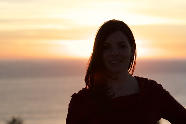 Smiling Woman Silhouetted Against Golden Sunset