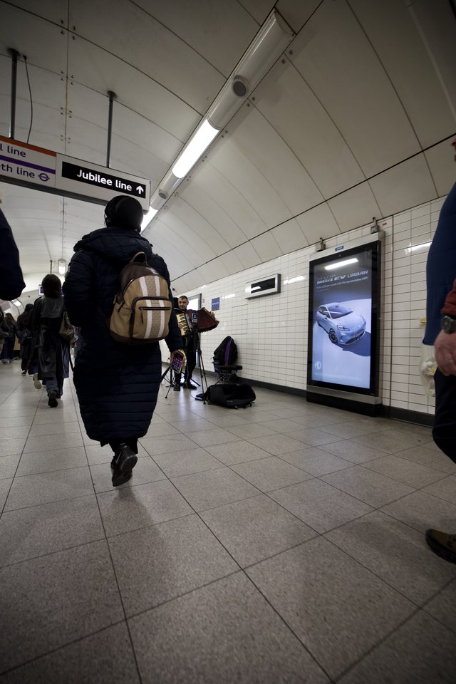Commuter Walking Through London Underground Station Corridor