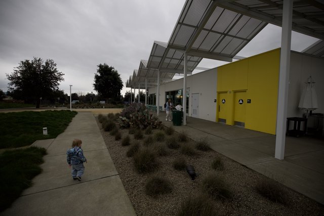 Child Walking at Modern Community Center with Solar Canopy