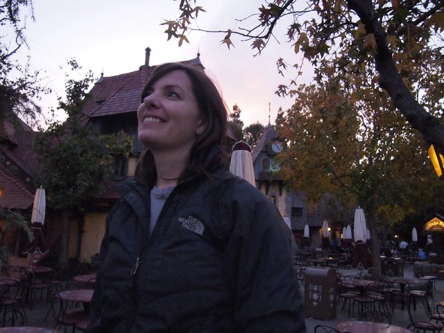 Smiling Woman at Dusk in Fairy-Tale Village Setting