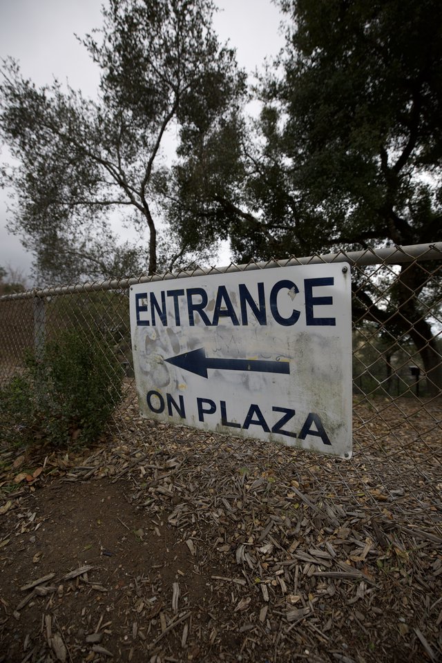 Weathered Entrance Sign Directing to Plaza