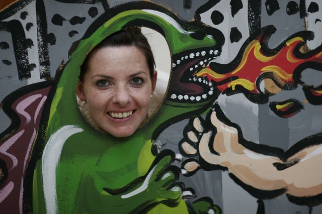 Woman Smiling Through Dragon Face Cutout Board