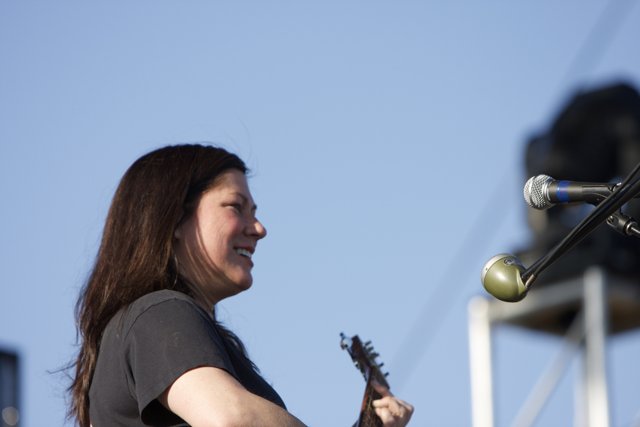 Kim Deal strums her guitar under the blue sky