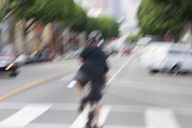 Blurred Cyclist on a Busy Road