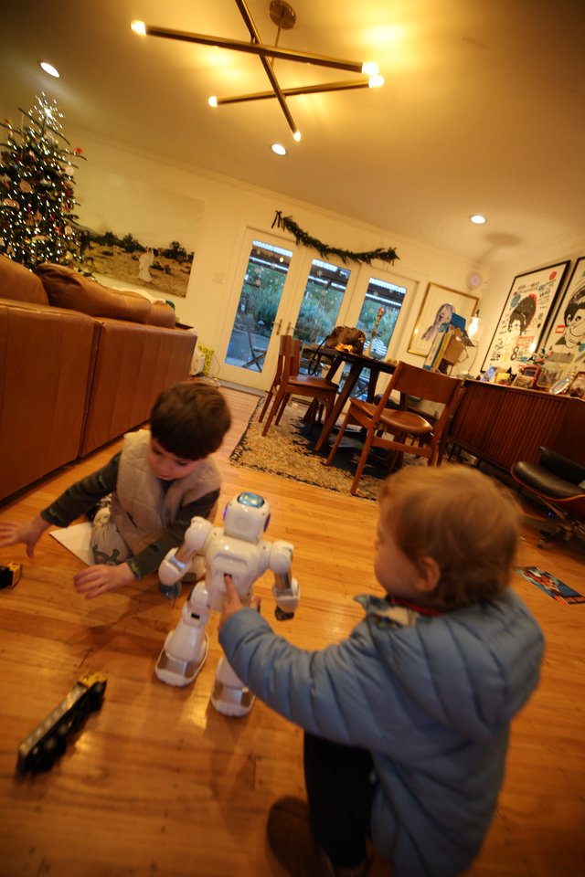 Children Playing with White Robot in Modern Living Room