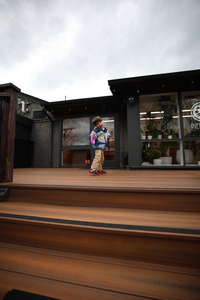 Child with Pink Backpack on Modern Wooden Deck