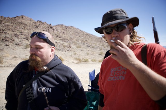 Bearded Man with Sunglasses and Hat Caption: Flea F takes in the beautiful blue sky and rolling hills while enjoying a smoke break with a friend.