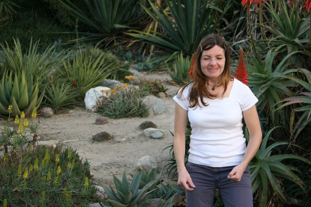 Woman Smiling Among Desert Succulents and Aloe