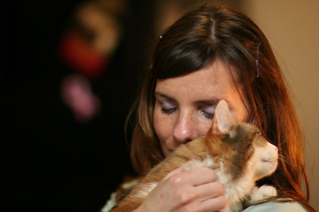 Tender Moment: Woman Nuzzles Beloved Kitten Closely
