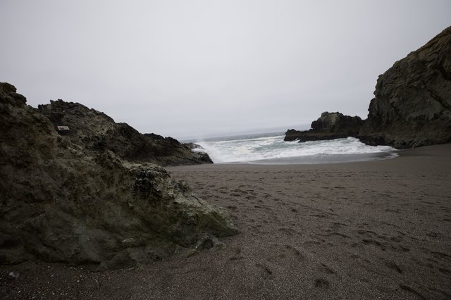 Wild Cove Beach Framed by Dark Sea Cliffs