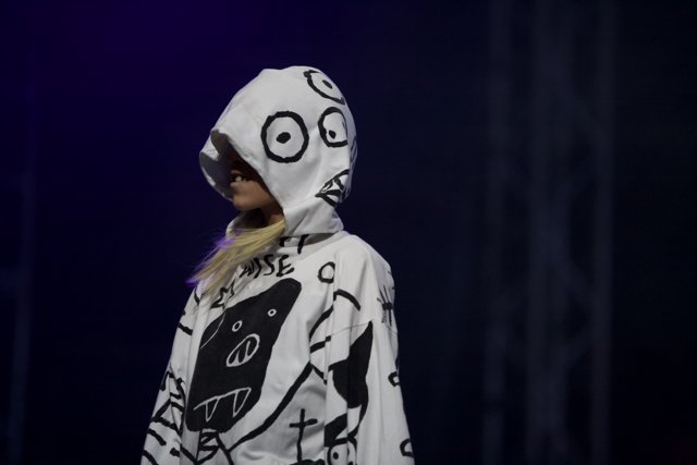 Hooded and Painted Performer Struts Down Coachella Runway