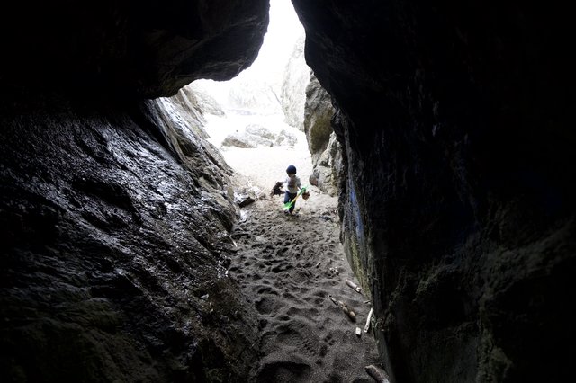Young Explorer Ventures Into Rocky Coastal Cave