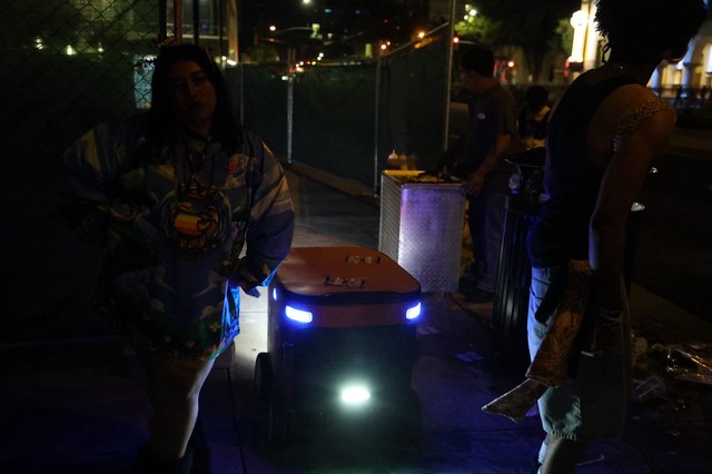 Delivery Robot Navigates Nighttime Festival Crowd