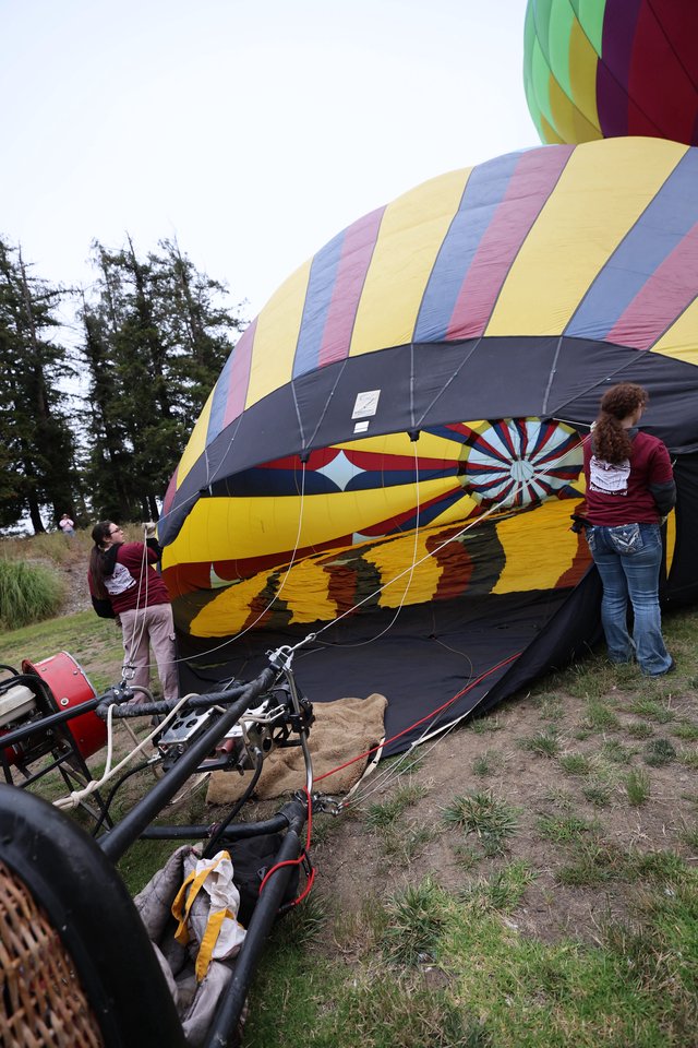 Ground Crew Inflating Colorful Hot Air Balloon at Festival