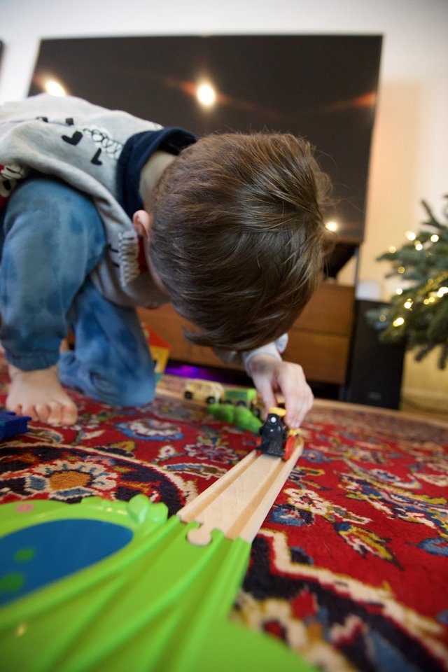 Child Playing with Wooden Train Set at Christmas