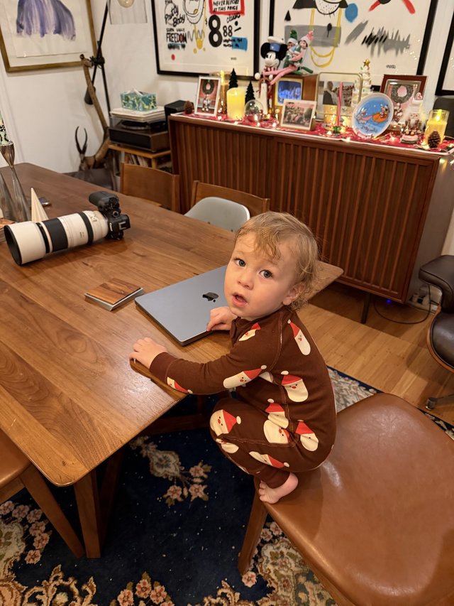 Toddler in Santa Pajamas at Home Workspace