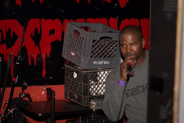 Steve J Holds Microphone in Front of Crate