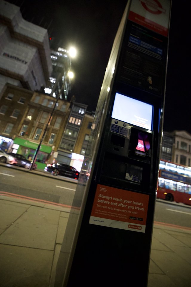 Night Scene at London Bus Stop with Health Advisory