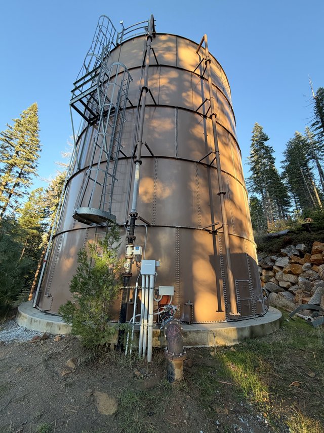 Industrial Steel Water Tank in Mountain Forest Setting