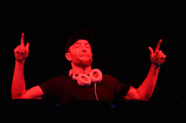DJ Lost in the Music Under Red Lights