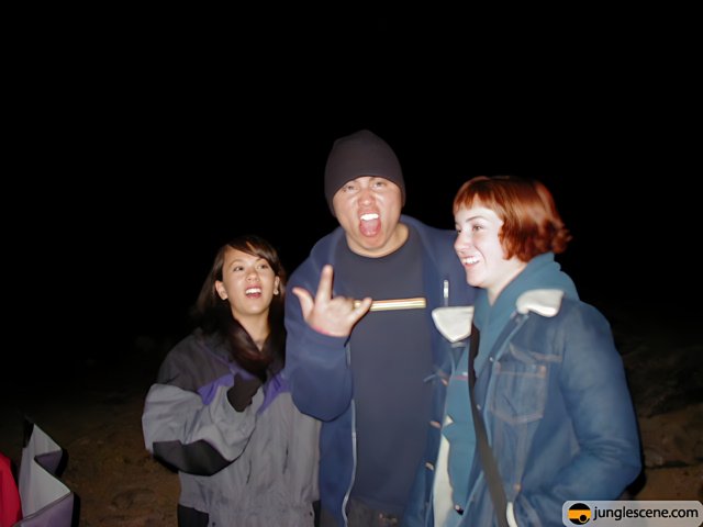 Nighttime Portrait of Three People in Jackets and Beanies