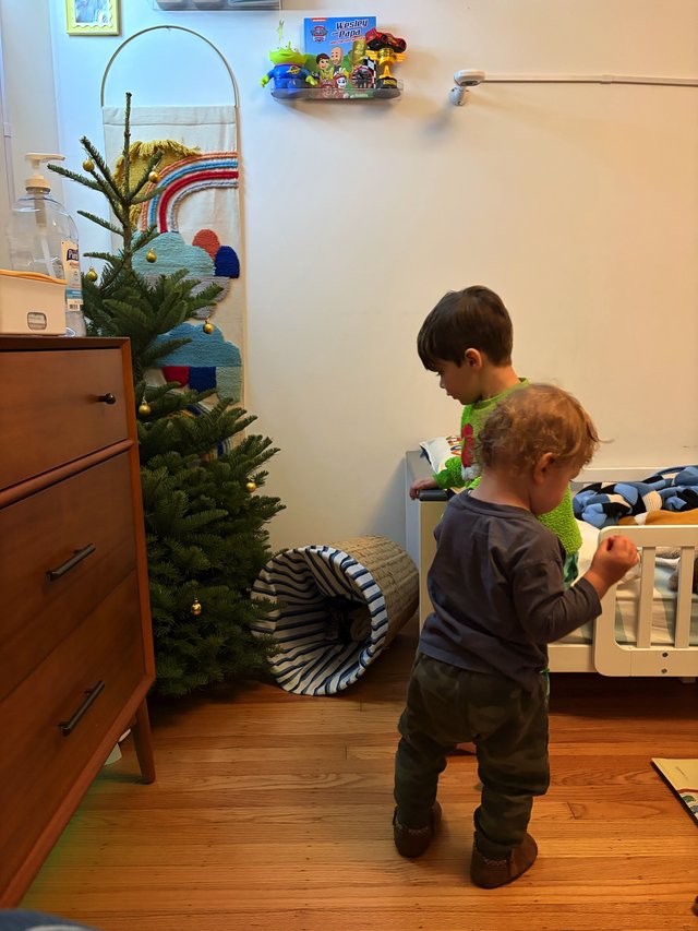 Two Young Children Exploring Their Christmas-Decorated Bedroom