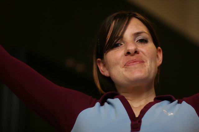 Woman in Aston Villa Kit Celebrates with Arms Raised