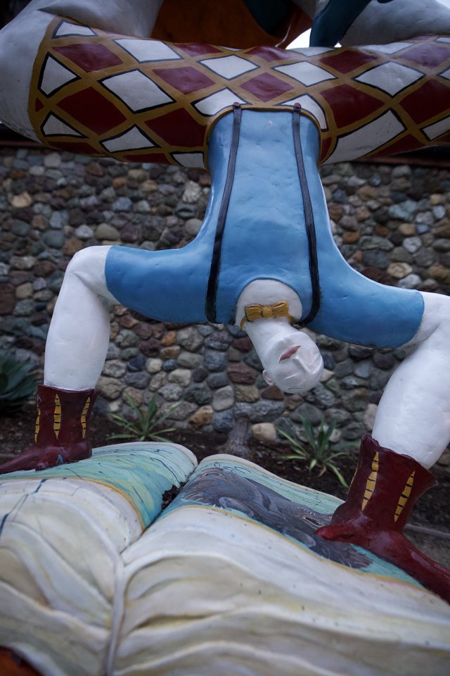Headless Figure Installation at Stone Wall Backdrop