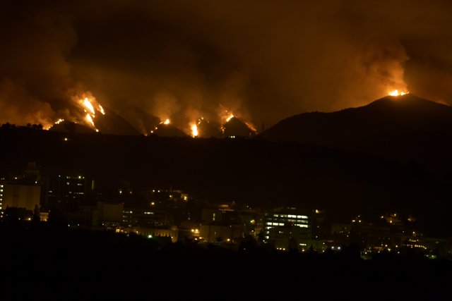 Flames Engulf Cityscape and Mountain Landscape