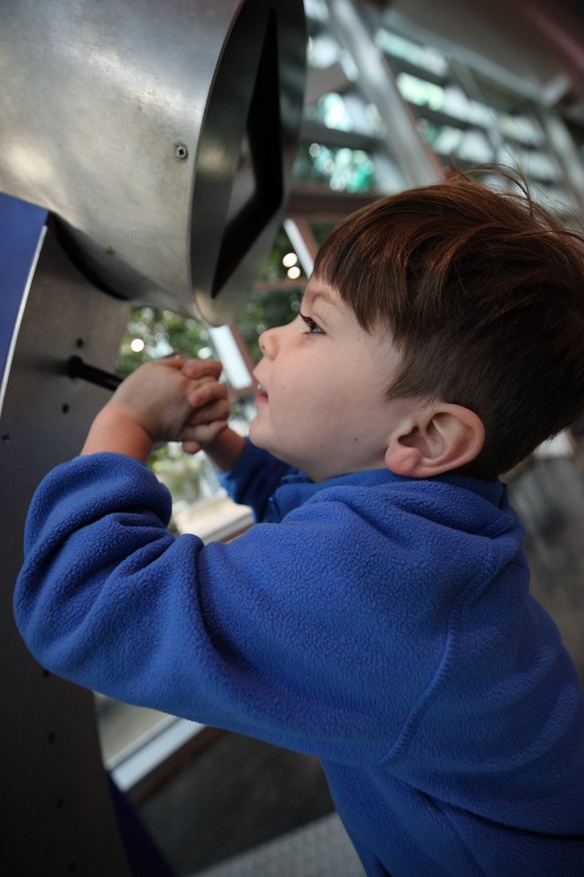 Young Boy Exploring Interactive Exhibit at Science Center