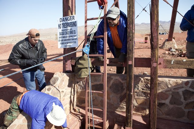 Three Workers Repair Walkway in Desert