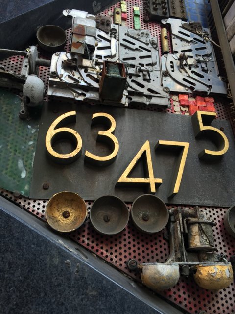 Numbers and Symbols on Rusty Metal Sign