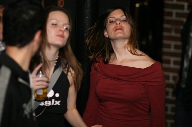 Two Women Dancing at a Dimly Lit Nightclub