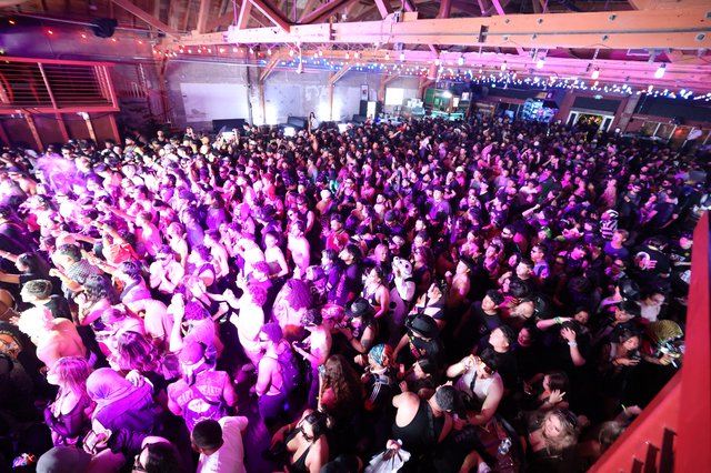Massive Indoor Crowd Pulsates Under Purple Festival Lights