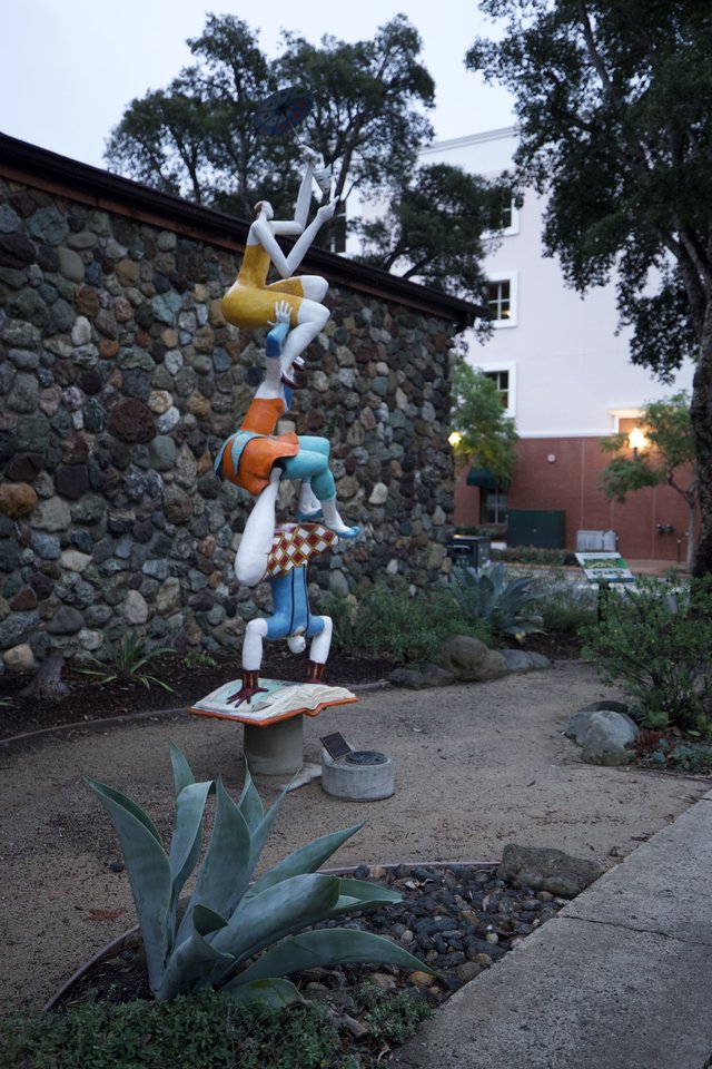 Whimsical Acrobatic Sculpture in Garden Setting at Dusk