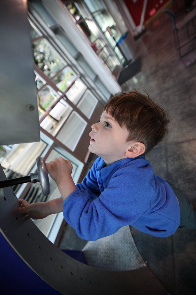 Young Boy Exploring Spiral Staircase at Science Center