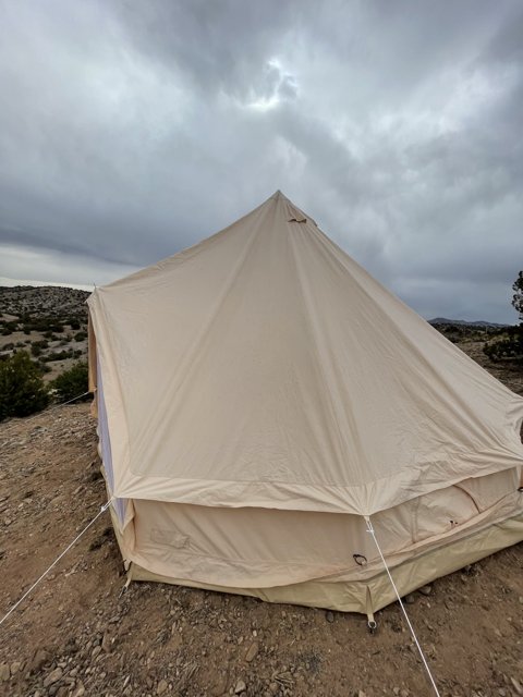 Mountain Tent under a Cloudy Sky
