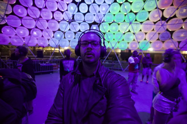 Electrifying Nightlife at Coachella: Man Listening to Music in Front of Large Dome