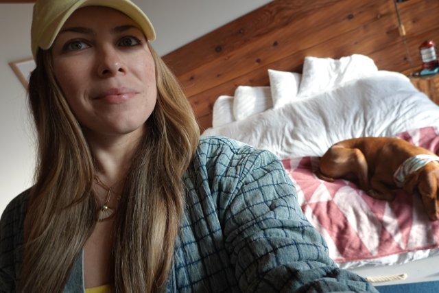 Yellow Hat and Comfy Bed: A Woman and Her Furry Companion
