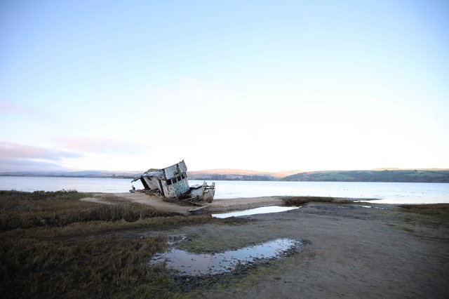 Abandoned Shipwreck at Twilight on Coastal Mudflats