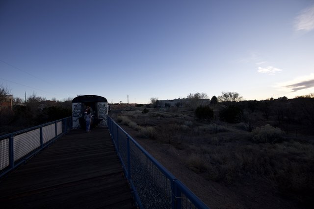 Twilight Crossing: Blue Bridge and Desert Landscape at Dusk