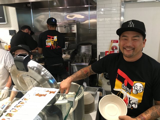 Smiling Chef with Tattoos Holds Bowl of Deliciousness